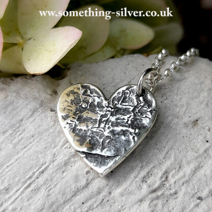 Sterling silver horse chestnut bark heart pendant with silver belcher necklace on natural stone background