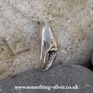 Sterling silver crab claw pendant with silver belcher chain on natural stone background